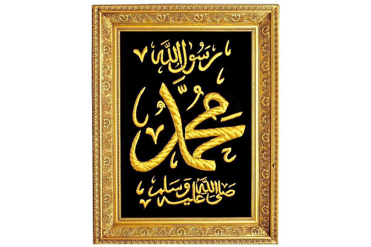 Discover exquisite Islamic wall art featuring the hand-embroidered name "Muhammad" (ﷺ) in gold silk thread on a black background. Framed in an ornate gold frame. Perfect for gifting on special occasions like Eid, weddings, etc. This Islamic decor art is available now with free UK delivery from Handmade EGY. Buy now!